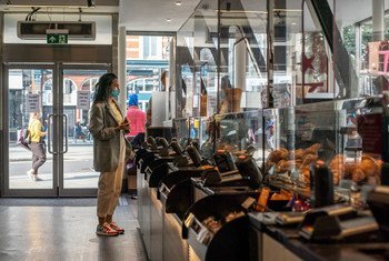 英国伦敦，一家连锁咖啡店内装上了透明挡板，顾客戴着口罩。（2020年9月图片）