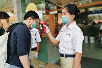 在缅甸仰光一个购物中心入口处，工作人员在检查顾客的体温。
