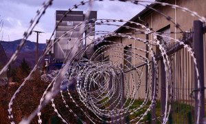 Barbed wire fencing surrounds a detention centre.