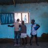 أطفال في جنوب السودان ينظرون عبر نافذة.