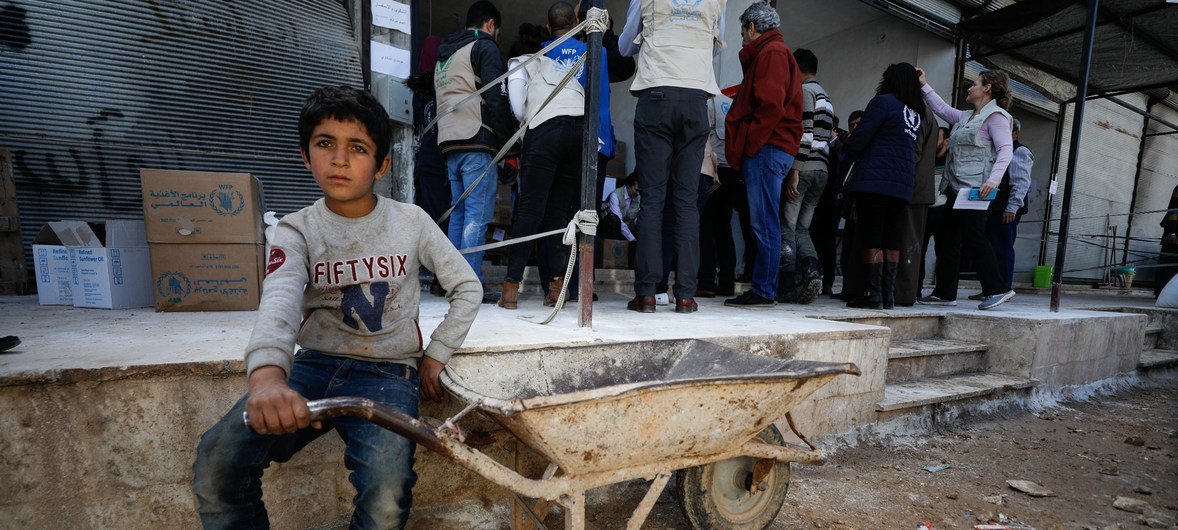 一名儿童在世界粮食计划署（WFP）位于叙利亚伊德利布南部农村总食品配送中心前等候。