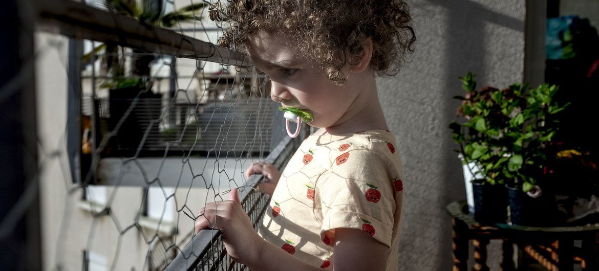 A three-year-old child looks outside their home in Lyon, France, during a lockdown due to the coronavirus pandemic.