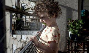 A three-year-old child looks outside their home in Lyon, France, during a lockdown due to the coronavirus pandemic.