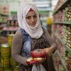 نور (22 عاما) لاجئة سورية تعيش في تركيا، تشتري الطعام في أحد المحلات التجارية باستخدام قسيمة المساعدات النقدية التي يقدمها برنامج الأغذية العالمي.
