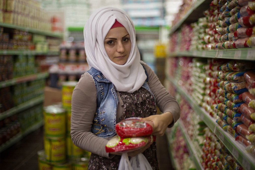 居住在土耳其难民营内的叙利亚难民使用粮食署提供的现金援助卡购买食品。