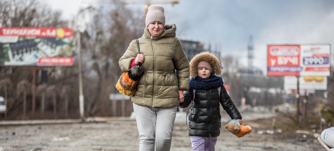 Une mère et sa fille fuient la violence à Bucha, dans l'oblast de Kyïv, en Ukraine.