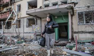 Una mujer camina frente a un edificio residencial destruido en Kyiv, Ucrania.