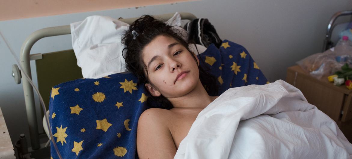 乌克兰基辅，一名受伤的女孩在病房里休息，她乘坐的汽车遭到炮击。