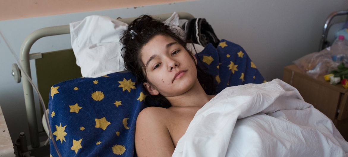 An injured girl lies in a medical ward in Kyiv, Ukraine, after her car exploded.