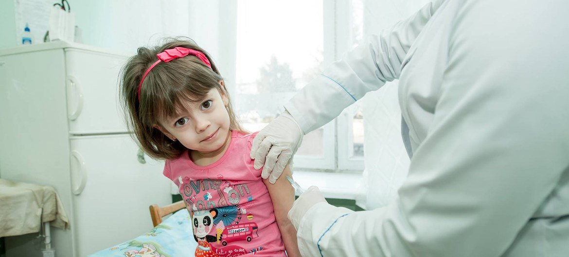 Une petite fille se fait vacciner en Ukraine.