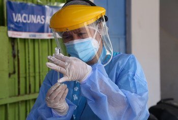 秘鲁利马的一名卫生工作者正在为老年人准备接种新冠疫苗。