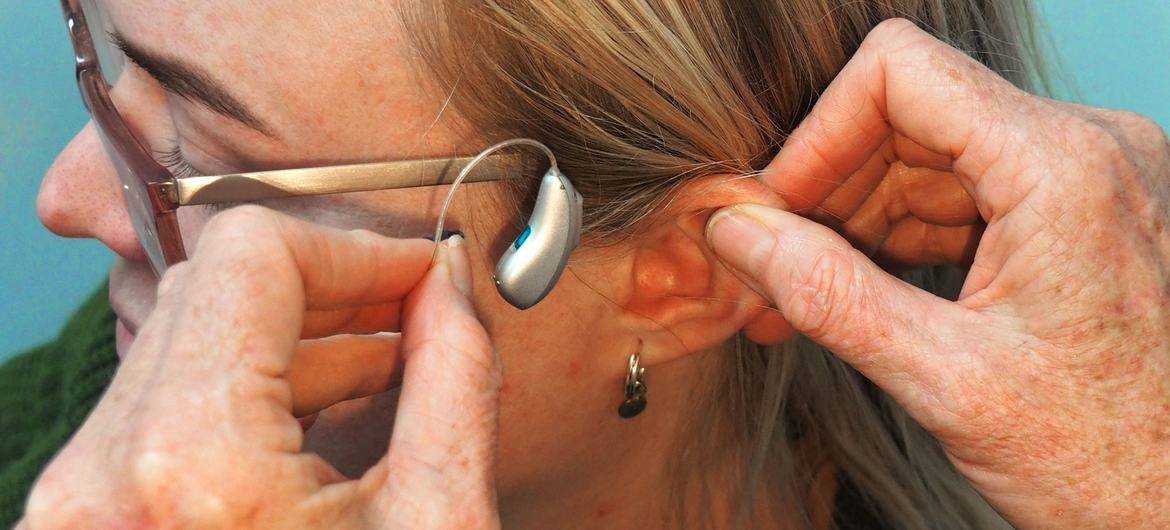 A woman being fitted for a receiver-in-canal (RIC) hearing aid.