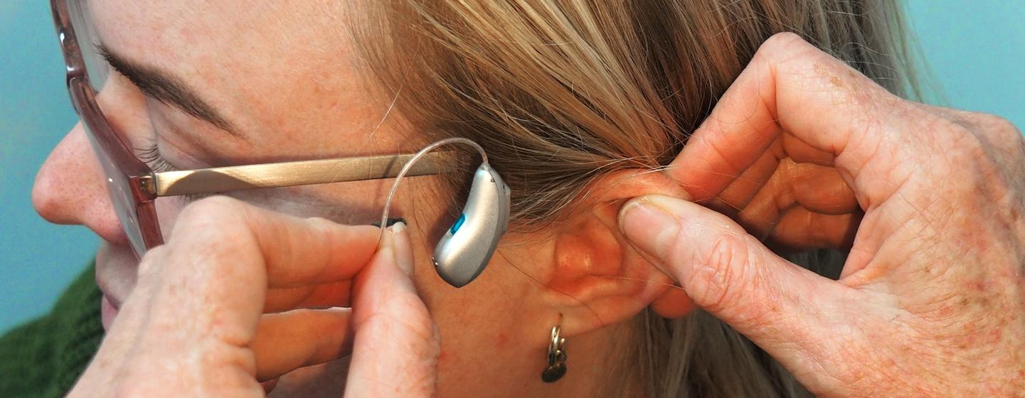 Une femme équipée d'une prothèse auditive à écouteur intégré (RIC).Unsplash/Mark Paton