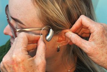 A woman being fitted for a receiver-in-canal (RIC) hearing aid.