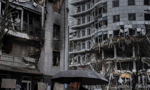一名男子走过乌克兰哈尔科夫被毁坏的一栋公寓楼。