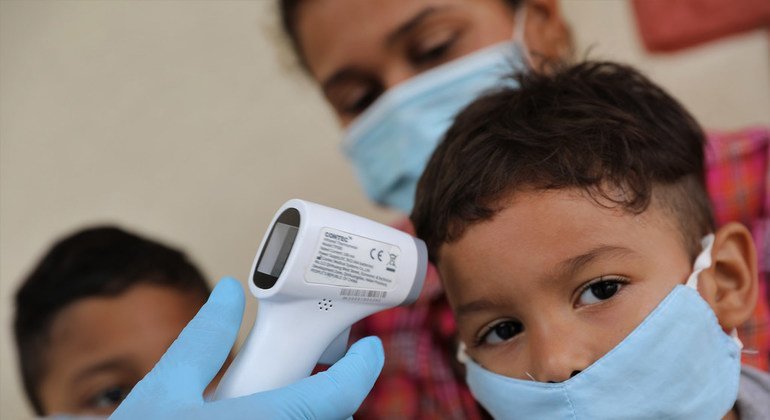 Un médico toma la temperatura a niño en Venezuela.