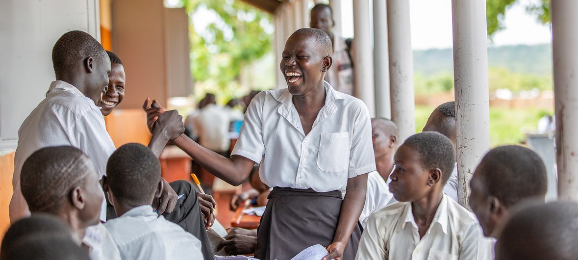 A schoolgirl in Uganda interacts with classmates.