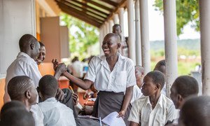 A schoolgirl in Uganda interacts with classmates.