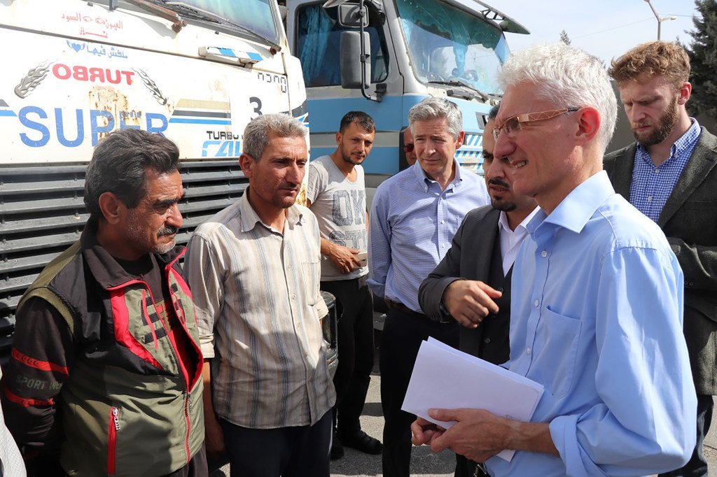 联合国人道主义协调员马克·洛科克（右）在土叙两国边界的土耳其一侧会见一群叙利亚司机。