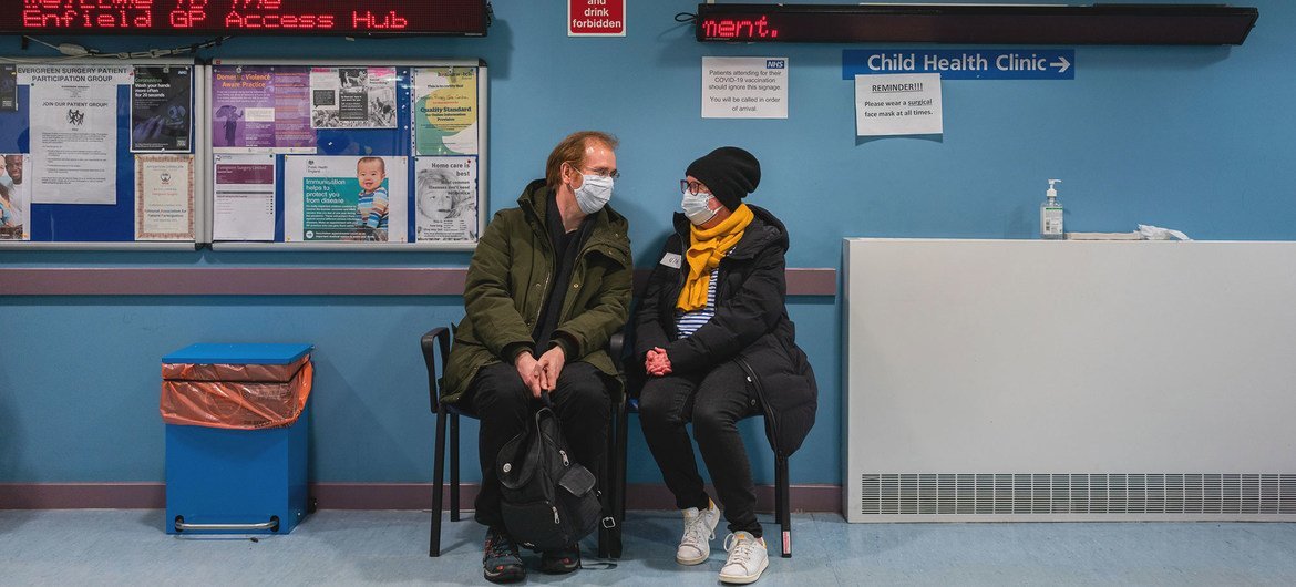 Two people wait to receive the COVID-19 vaccine at a clinic in the UK