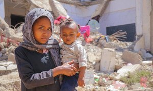 一个年轻女孩和她的弟弟在也门因冲突而流离失所的难民营里
