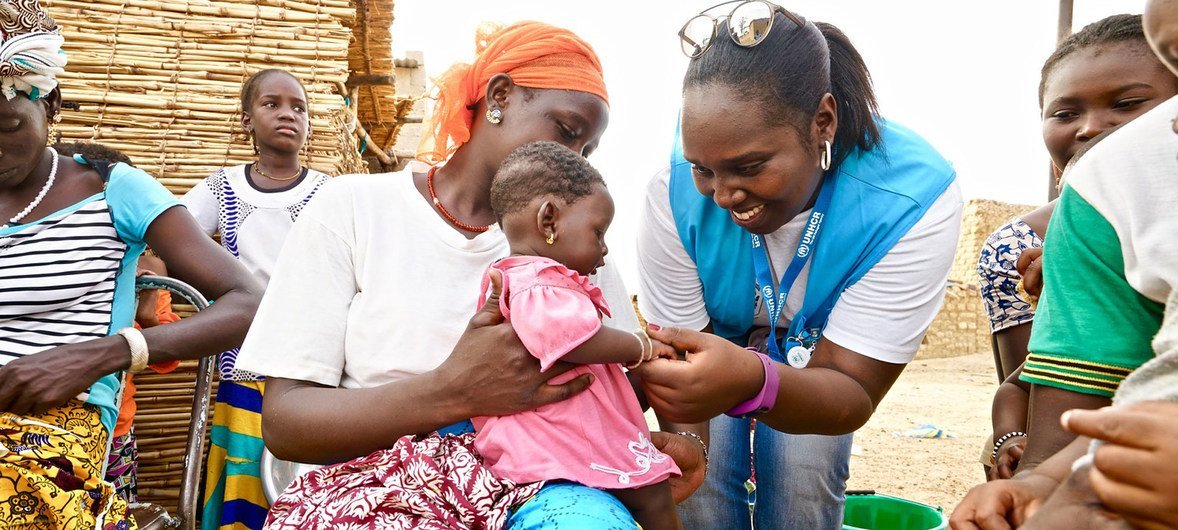 Un travailleur humanitaire de l'agence des Nations Unies pour les réfugiés (HCR) s'occupe d'un bébé dans un centre de santé soutenu par l'ONU dans la région nord du Burkina Faso.