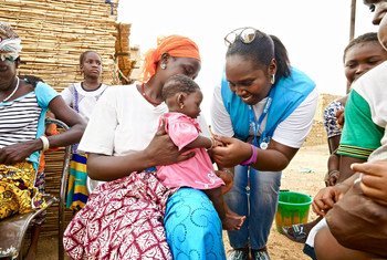 Un travailleur humanitaire de l'Agence des Nations Unies pour les réfugiés (HCR) s'occupe d'un bébé dans un centre de santé soutenu par l'ONU dans la région nord du Burkina Faso.