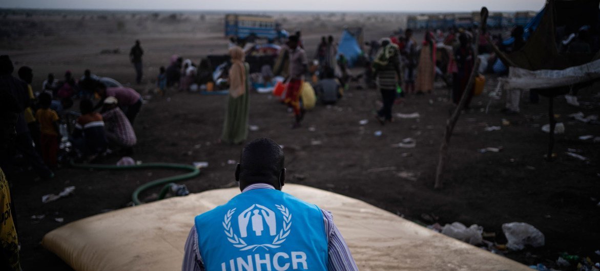 A UNHCR staff member ensures Ethiopian refugees in Hamdayet, Sudan, have access to water.