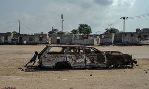 A young boy with a burned-out car is evidence of the intense fighting in 2015, when Houthi forces were driven out of the city in fierce fighting for the 'Battle of Aden'.
