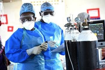 Médicos preparam cilindros de oxigênio em enfermaria de Covid-19 em hospital em Uganda.
