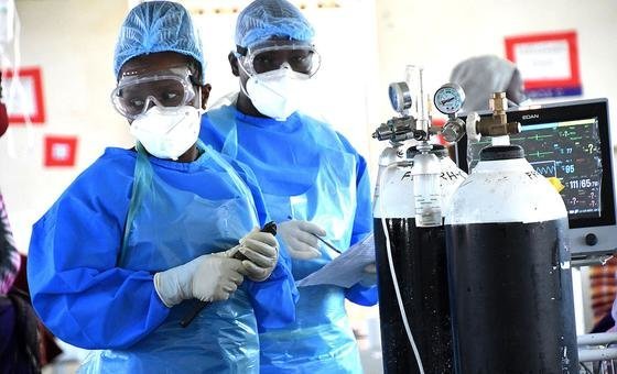 Médicos preparam cilindros de oxigênio em enfermaria de Covid-19 em hospital em Uganda.