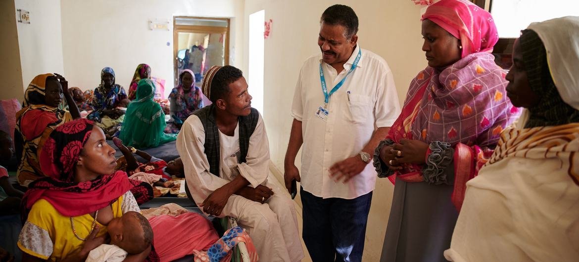 A doctor speaks to a family in a health facility for severe malnutrition in Sudan.