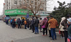 В одном из городов Китая, где не утихает эпидемия нового коронавируса,  люди вынуждены стоять в очереди за защитными масками. 