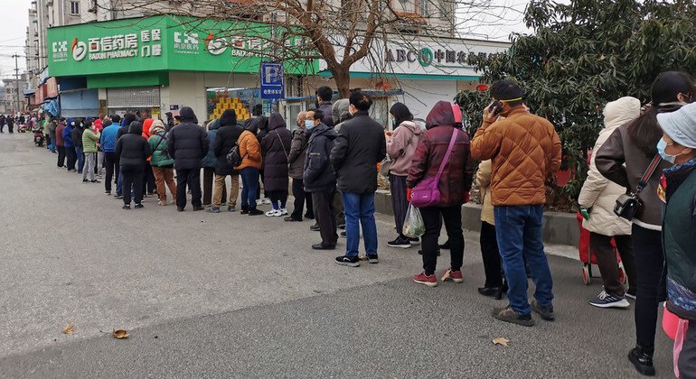 Residentes en la ciudad china de Nanjing hacen cola para comprar mascarillas contra el coronavirus.
