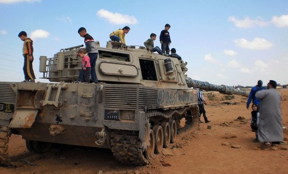 دبابة مدمّرة أصبحت أداة يلعب بها الأطفال في بنغازي بليبيا (آذار/مارس 2011)