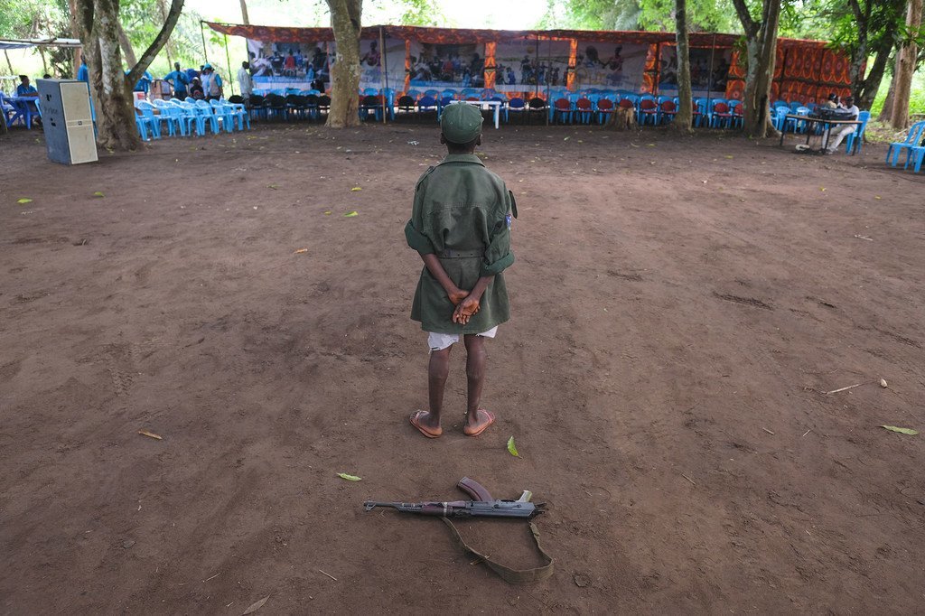 Mtoto akiwa amesimama wakati wa tukio la kusalimisha silaha kutoka vikundi vilivyojihami na kuanza mchakato wa kujumuishwa kwenye jamii. Hapa ni Yambio nchini Sudan Kusini