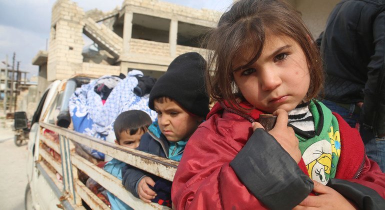 Niños en la parte de atrás de un camión huyen con sus familias de los combates en Idlib, Siria. 