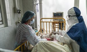 A mother and a doctor tend a girl with COVID-19 at an intensive care ward, in Chernivtsi, Ukraine.