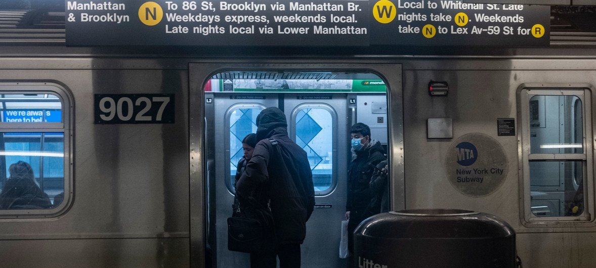 纽约地铁上的通勤者戴着口罩，以防冠状病毒的传播。