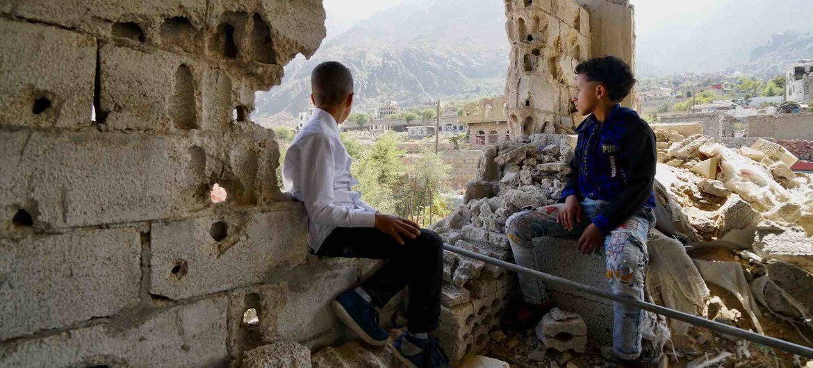 Two children, who recently returned home after they and their family fled fighting in 2017, look out over the Al Gamalia neighborhood of Taiz City.