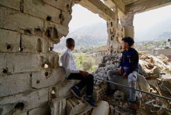 Deux enfants, qui sont récemment rentrés chez eux après qu'eux-mêmes et leur famille aient fui les combats en 2017, regardent le quartier Al Gamalia de la ville de Taiz.