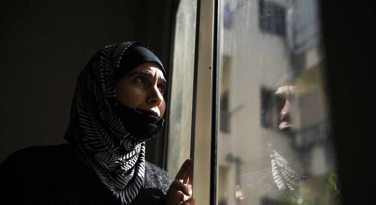 اللاجئة السورية حلا تقف أمام نافذة منزلها في لبنان.