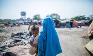 A mohter holds her child in the slum where they live in Vijaynagar, India.
