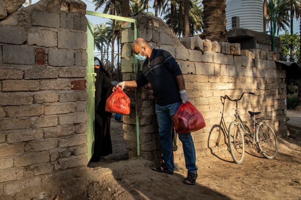 在伊拉克，一名为开发署支持的团体工作的志愿者向位于伊拉克卡尔巴拉郊区的塔里杰区的一个弱势家庭运送食品。