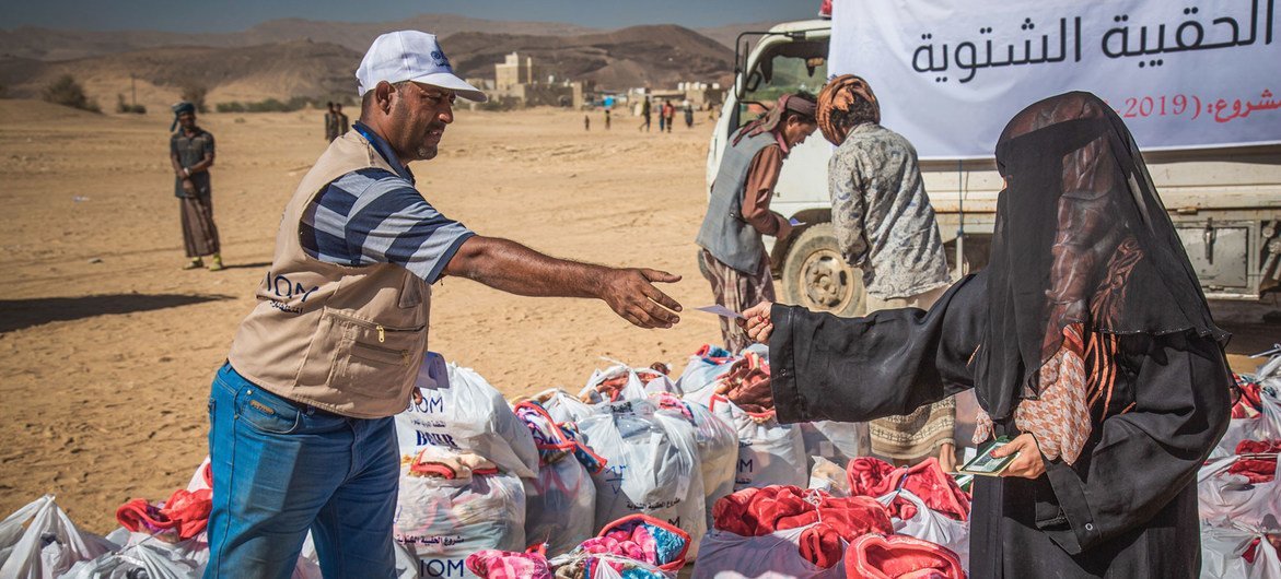 امرأة نازحة تتلقى حزمة مساعدات في موقع التوزيع في مأرب، اليمن.