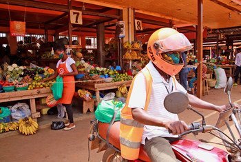 A SafeBoda rider and market vendor use the SafeBoda app to deliver food and supplies during the COVID-19 lockdown in Kampala, Uganda.
