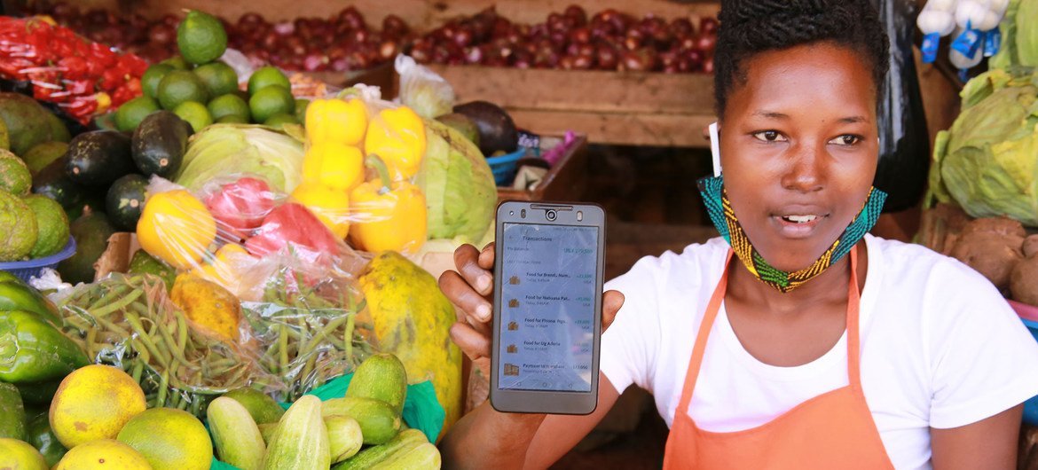 A market vendor uses the SafeBoda app which connects vendors to households using the SafeBoda transport service during the COVID-19 lockdown in Kampala, Uganda.