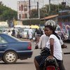 A Boda Boda rider and passenger wait at a junction in Kampala, Uganda.