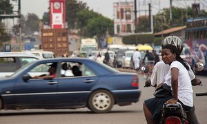 A Boda Boda rider and passenger wait at a junction in Kampala, Uganda.
