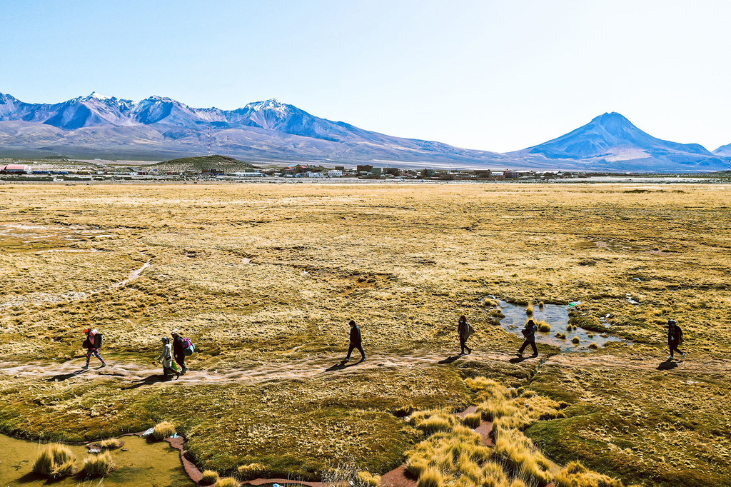 Toma aérea de migrantes venezolanos caminando por el desierto de Atacama.
